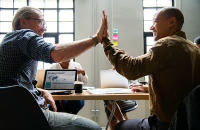 Creative professional and job requester shaking hands in a creative kick-off meeting