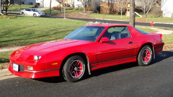 the cranky creative red camaro sitting at the curb