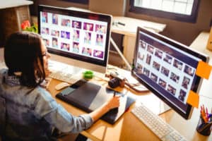 professional graphic designer working at two screens