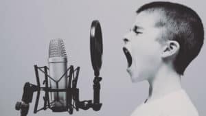 obnoxious boy yelling into a microphone to get attention