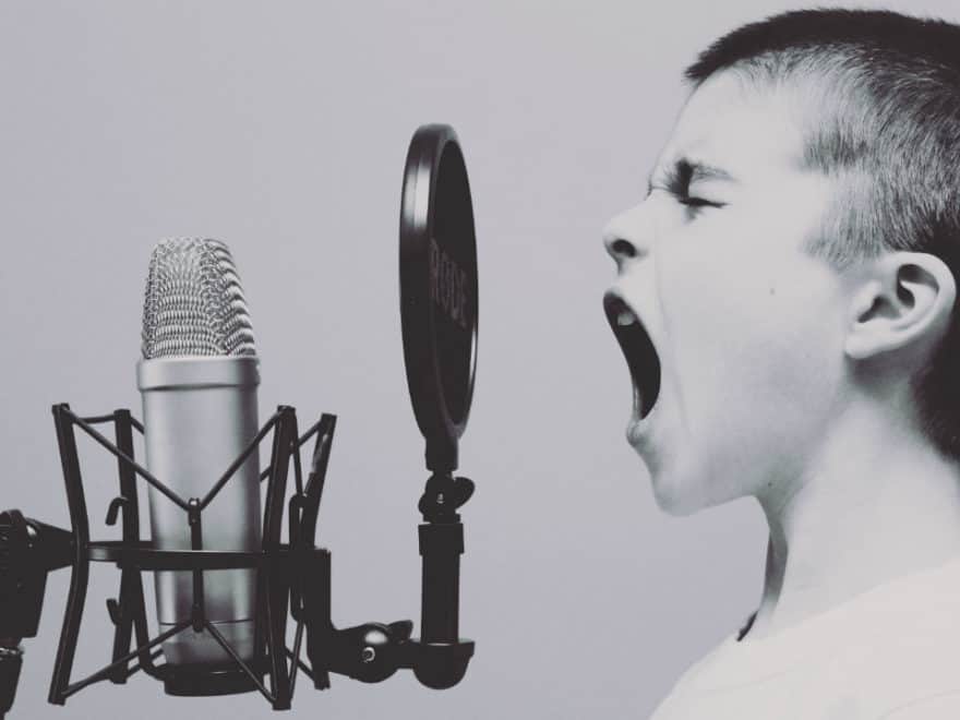 obnoxious boy yelling into a microphone to get attention