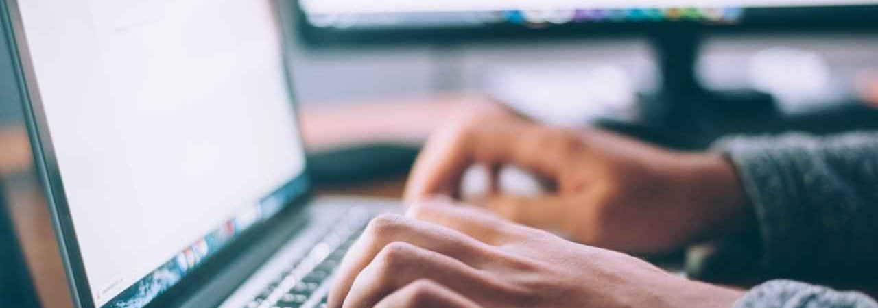 The Cranky Creative. Photo of male copywriter hands typing on a laptop keyboard