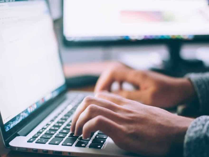 The Cranky Creative. Photo of male copywriter hands typing on a laptop keyboard