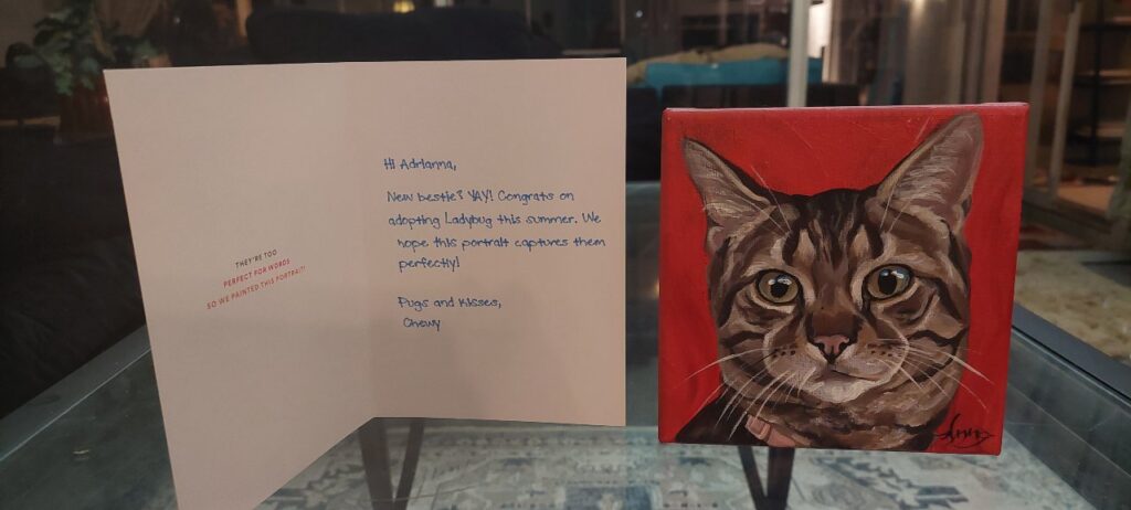 A greeting card and painting Chewy sent us to welcome our new cat