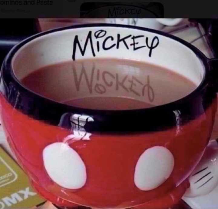 A Disney coffee mug with the word Disney casting a reflection that reads Wicked in the coffee