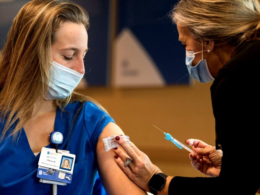 Health care provider gives a woman a vaccine.